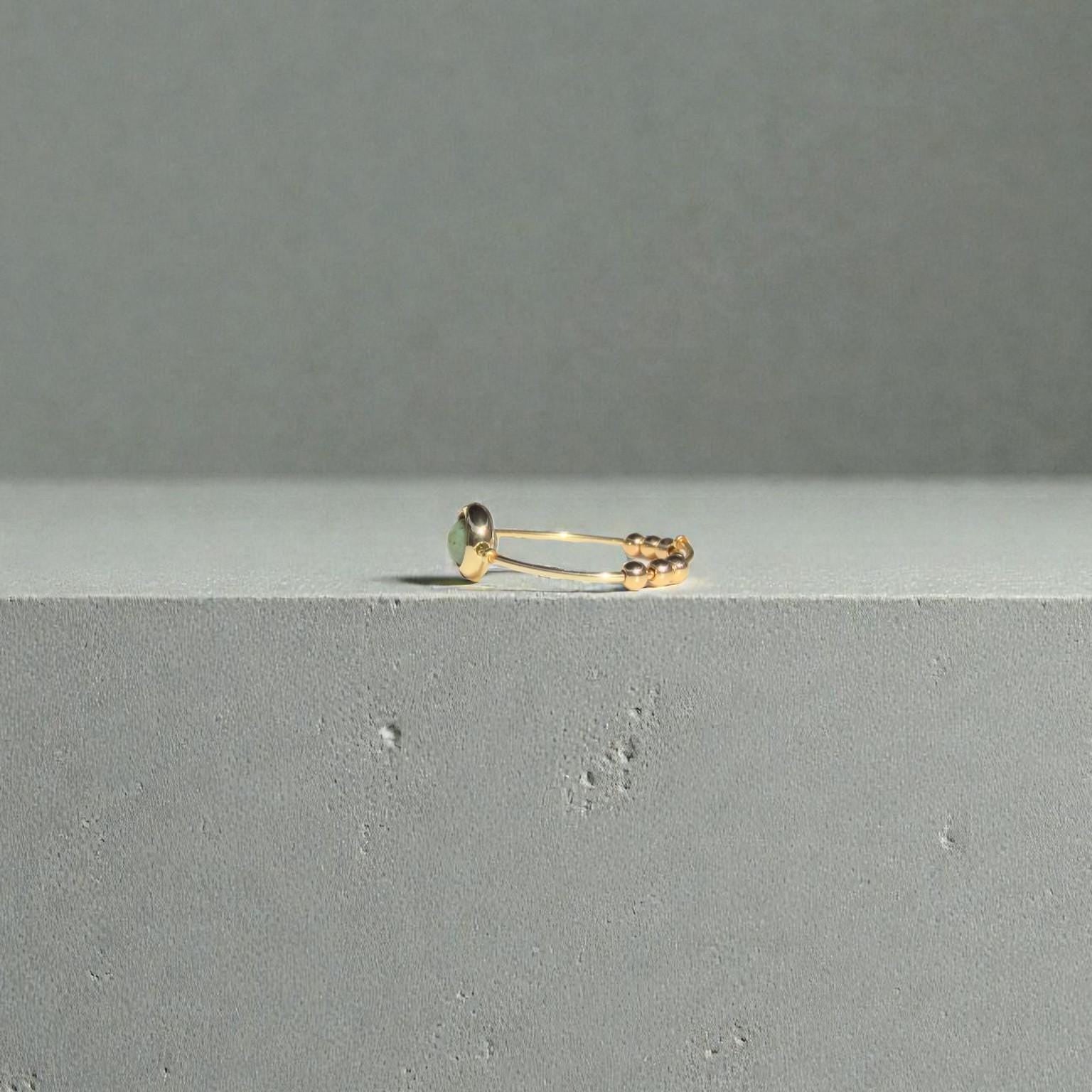 African Turquoise Gemstone Fidget Ring on a gray surface with a gray background