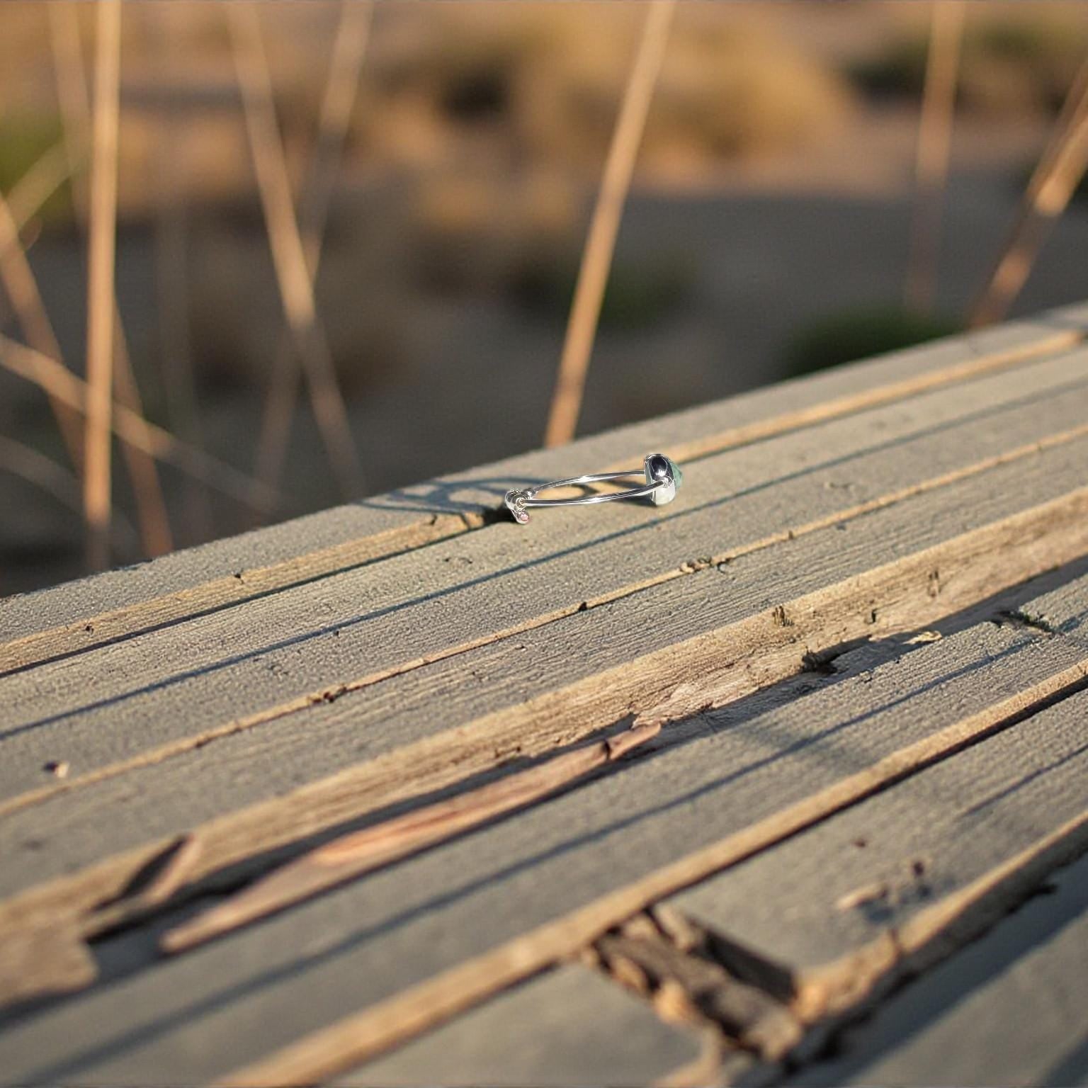 Sideview of a natural emerald ring wooden surface with a blurred natural background