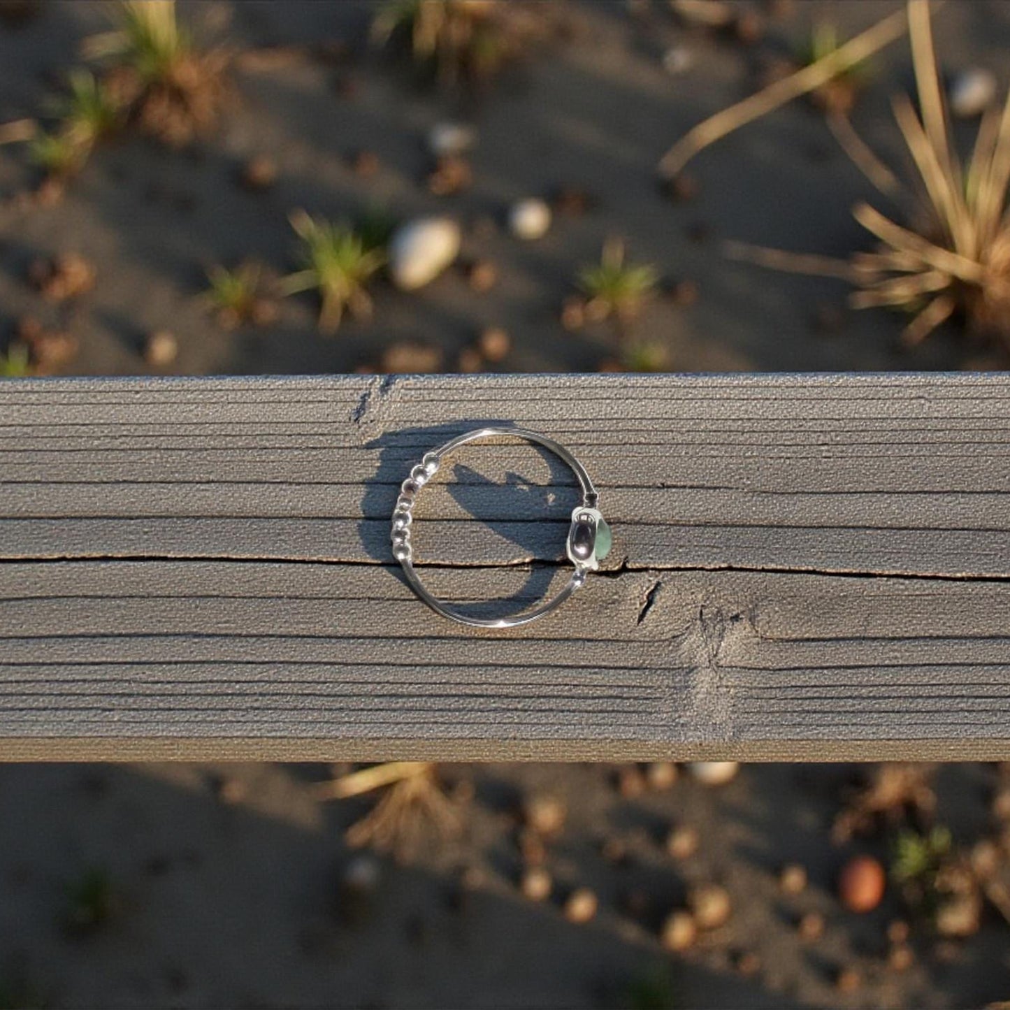 Top view of a natural emerald ring on a wooden surface with a natural background