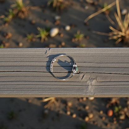 Top view of a natural emerald ring on a wooden surface with a natural background